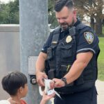 Police captain giving a sticker to a child